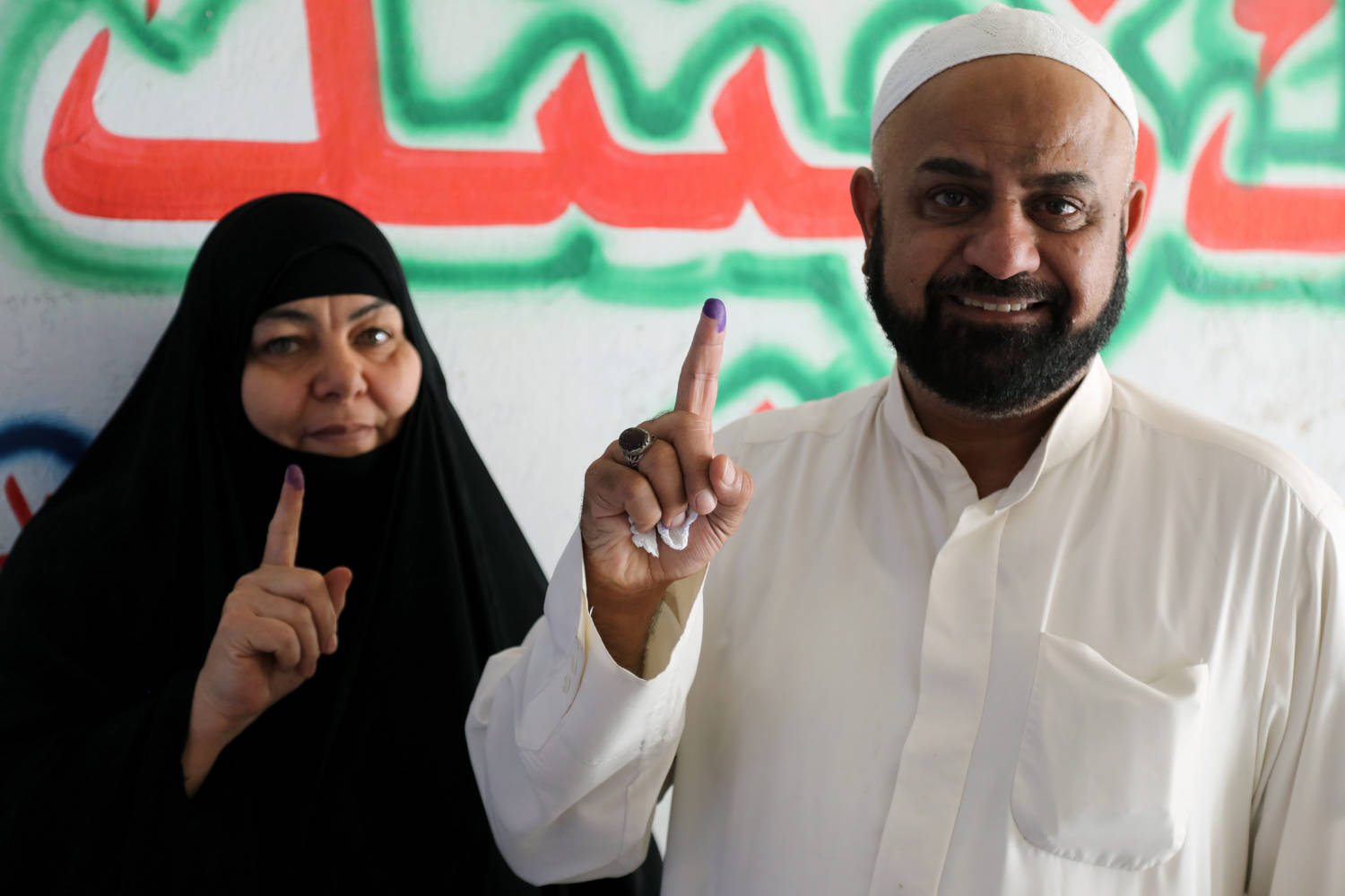 Иракско семейство показва намастилените си показалци след като е гласувало
