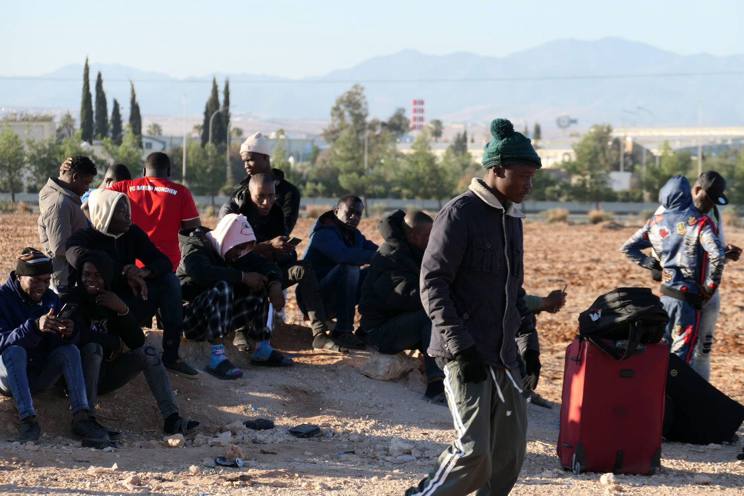 Мигранти стоят пред бежанския лагер в кипърското село Кокинотримитиа. Никос