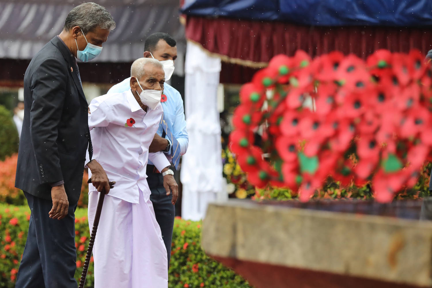Възрастен ланкийски ветеран от войните подкрепян от млади войници на