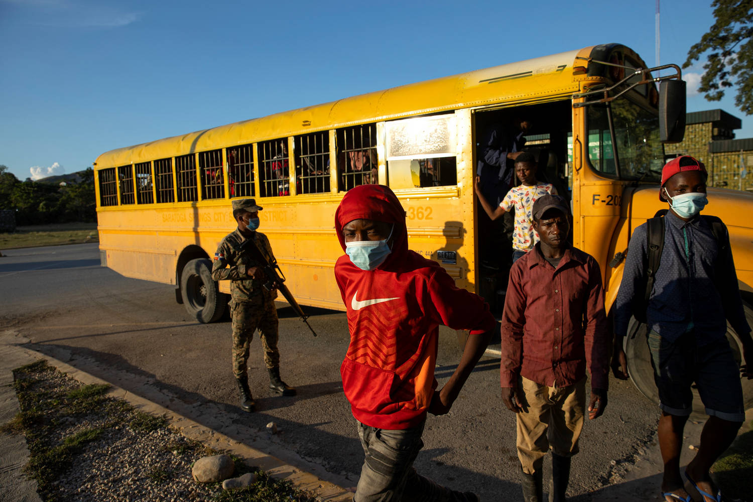 Служител от доминиканската армия надзирава автобус с 52 мигранти от